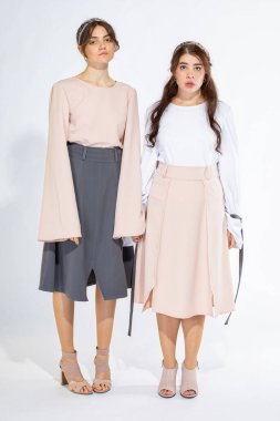 İki beyaz Avrupalı model kadın açık gri üzerinde izole edilmiş.