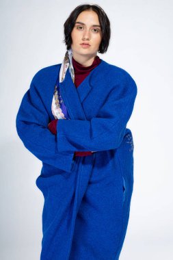 Mavi kışlık ceketli, açık gri giysili Avrupalı beyaz kadın