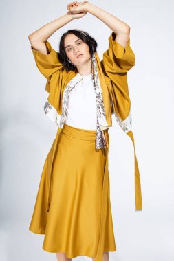 Açık gri üzerine izole edilmiş, elleri başının üstünde beyaz bir kadın.