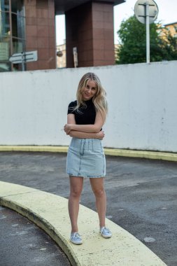 Avrupalı genç beyaz kız beton yeraltı otoparkının yanında yürüyor