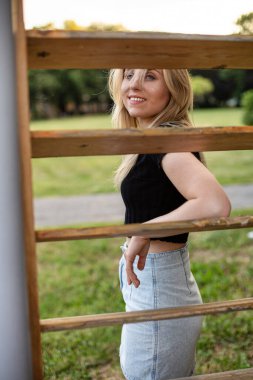 Tebessüm eden Avrupalı genç model kız çitin arkasında.