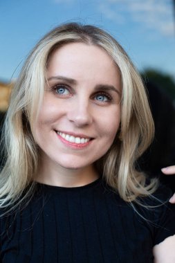 Mavi gözlü, gülümseyen beyaz kadın portresi