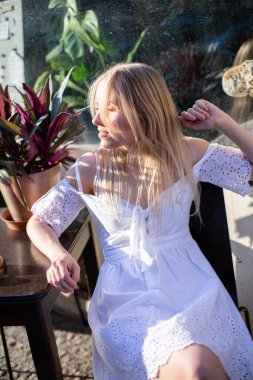 Bitkilerin yanında sarı saçlı genç Avrupalı beyaz bir model.