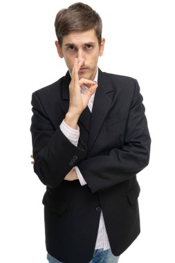 Genç yakışıklı, uzun boylu, zayıf, kahverengi saçlı, siyah ceketli, beyaz arka planda iyi bir işaret gösteren beyaz bir adam.