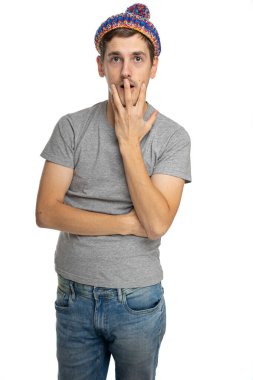 Genç, uzun boylu, zayıf, kahverengi saçlı, beyaz arka planda izole edilmiş mavi kot pantolonlu, gri gömlekli, yakışıklı, beyaz bir adam.