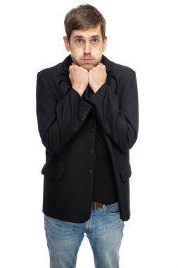 Genç yakışıklı, uzun boylu, zayıf, kahverengi saçlı, beyaz arka planda izole edilmiş kot pantolonlu, siyah ceketli, yardıma muhtaç beyaz bir adam.