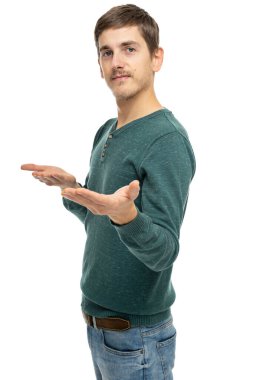 Genç yakışıklı, uzun boylu, zayıf, kahverengi saçlı, beyaz arka planda izole edilmiş koyu yeşil kotlu, davetkar bir süveter giyen beyaz bir adam.