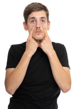 Siyah gömlekli, beyaz arka planda izole edilmiş kahverengi saçlı, uzun boylu, zayıf beyaz bir adam.