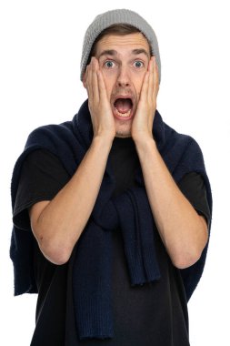 Genç yakışıklı, uzun boylu, zayıf, kahverengi saçlı, beyaz arka planda gri kış şapkalı, siyah gömlekli, korkak beyaz bir adam.