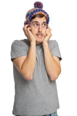 Genç yakışıklı, uzun boylu, zayıf, kahverengi saçlı, gri gömlekli, beyaz arka planda izole edilmiş, kış şapkalı, yakışıklı, beyaz bir adam.