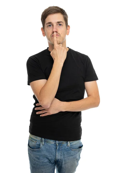 年轻英俊 身材苗条 一头棕色头发的男人 用手指捂住嘴 穿着黑色衬衫 背景是白色的 — 图库照片