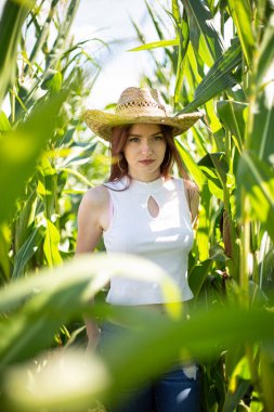 Uzun otların arasında duran siyah saçlı beyaz kız.