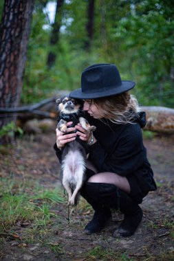 Arkasında ağaçlar olan beyaz bir genç kadın.