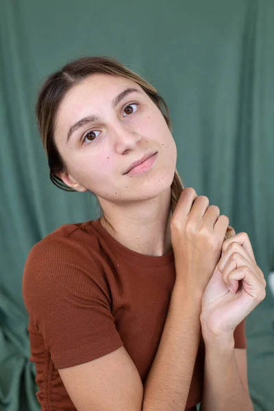 緑に隔離された顔の近くに手を持つ肖像画の女性 — ストック写真