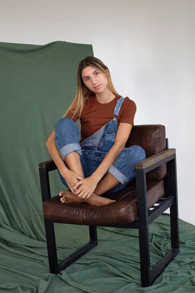 Bella Donna Bianca Seduta Una Sedia Sfondo Parzialmente Verde Studio — Foto Stock