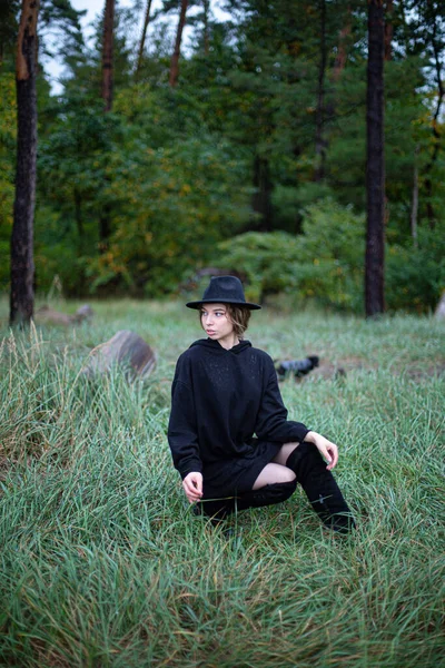 森の後ろに暗い服を着た白い若い女性 — ストック写真