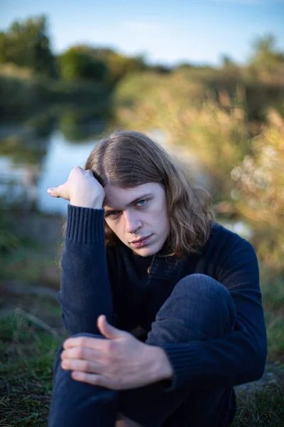 Молодой Европейский Мужчина Длинными Волосами Озером Позади — стоковое фото