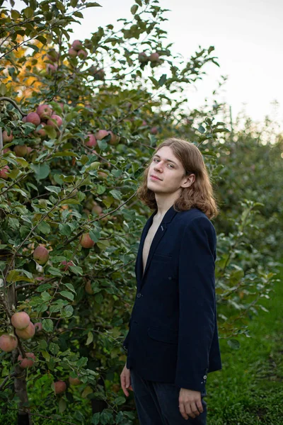 若いヨーロッパの白い男と長い髪の木の近くにリンゴ — ストック写真