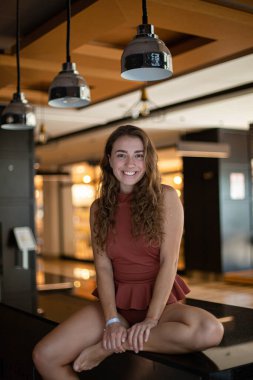 Restoranda oturan mayolu, gülümseyen Avrupalı genç bir kadın.