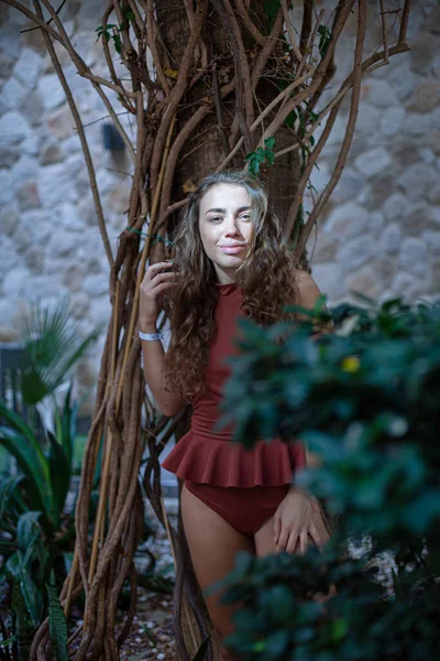Europejska Dziewczyna Kręconymi Włosami Ścianą Blisko Egzotycznego Pnia Drzewa — Zdjęcie stockowe