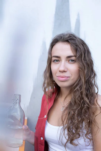 Νεαρό Ευρωπαϊκό Κορίτσι Σγουρά Μαλλιά Τοίχο Πίσω Και Ένα Μπουκάλι — Φωτογραφία Αρχείου