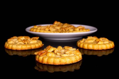 Siyah camlı, beyaz seramik tabakta fıstıklı altı tane lezzetli kurabiye.