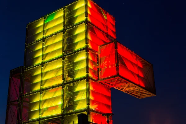 Una construcción de acero gigante con iluminación de colores en la noche . —  Fotos de Stock