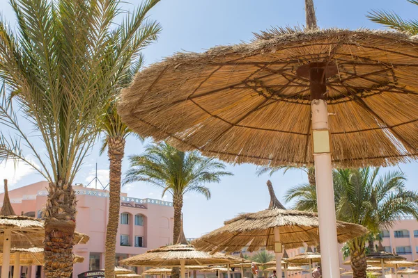 Stro parasols op het strand in de omgeving van het hotel — Stockfoto