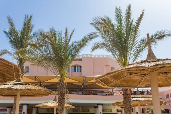 Stro parasols op het strand in de omgeving van het hotel — Stockfoto