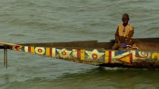 空中ドローンショット男の子が運河や川で木のボートに微笑んだ後 ボツワナ — ストック動画