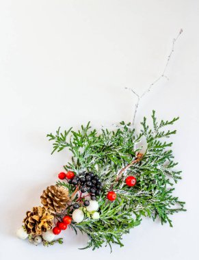 Noel ve Yeni Yıl kartı, kompozisyon, ladin, koni, beyaz arka planda böğürtlen. Düz konum, boşluk kopyala, üst görünüm