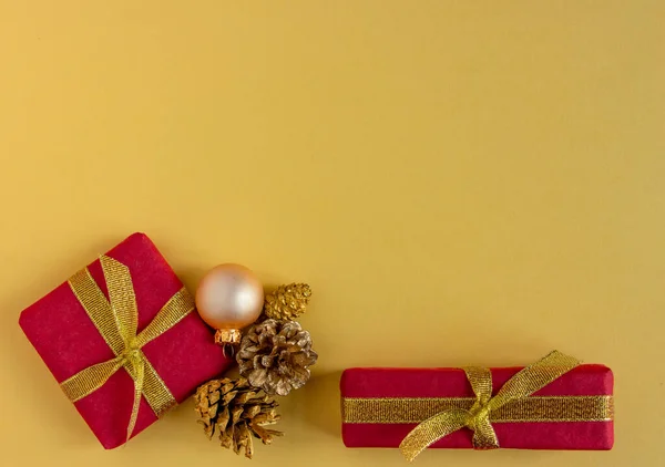 Noel ve yeni yıl tebrik kartı, geçmiş - hediyeler, sarı renkli koniler, şık. Düz konum, boşluk kopyala, üst görünüm