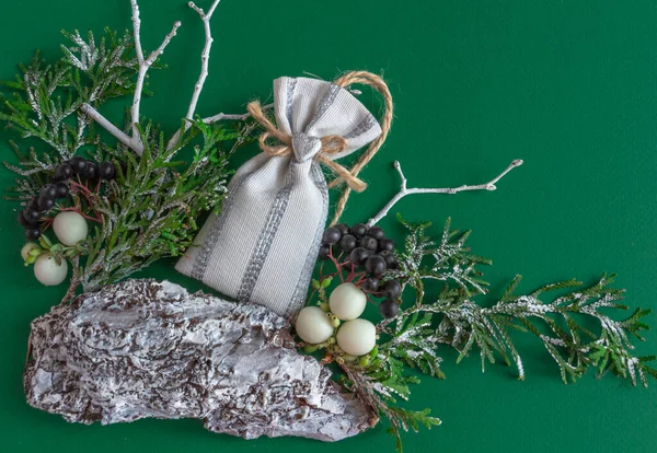 Boże Narodzenie, karta noworoczna - gałązki jodły, worek prezentów na zielonym tle, stylowe. Płaskie ułożenie, przestrzeń kopiowania, widok z góry — Zdjęcie stockowe