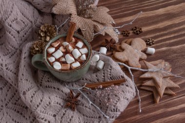 Atmosferik Noel kompozisyonu, bir fincan marşmelovlu kakao, zencefilli kurabiye, tatlı, tarçın.