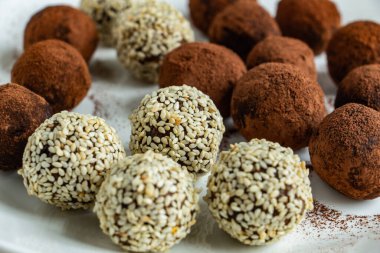 Kakaolu trüf mantarı, hindistan cevizi ve çikolata ve marşmelovlu susam tohumu, beyaz arka planda lezzetli bir tatlı.