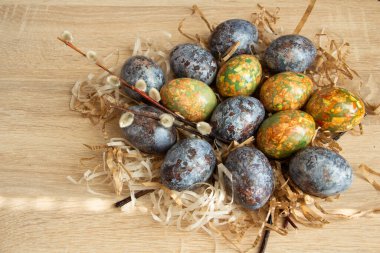 Güzel Paskalya kompozisyonu - mermere benzeyen renkli yumurtalar, buğday kulakları, söğüt dalları, geleneksel olarak, el yapımı.