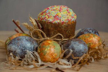 Güzel Paskalya kompozisyonu - renkli yumurtalar, Paskalya pastası, buğday kulakları, geleneksel olarak zarif..