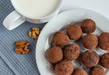 Kakaolu trüf mantarı, hindistan cevizi ve susamlı çikolata ve marşmelov ve bir fincan taze süt, lezzetli tatlı.