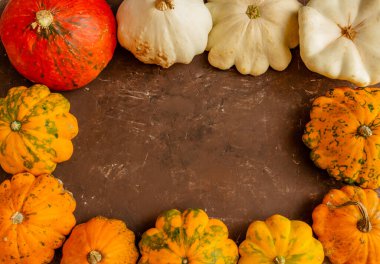 Sonbahar kompozisyonu, kahverengi arka planda balkabağı, Şükran Günü ya da Cadılar Bayramı konsepti. Düz konum, boşluk kopyala, üst görünüm