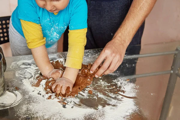 Fathers Day concept. Father and son makes a dough, bakes cookies at home. Homemade baking. Family time concept. Father and son together
