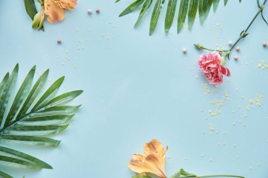 Tropikal yapraklar, çiçekler ve tozla dolu parlak yaz arkaplanı. Güzellik konsepti uzayı taklit ediyor. Kadınsı kavram