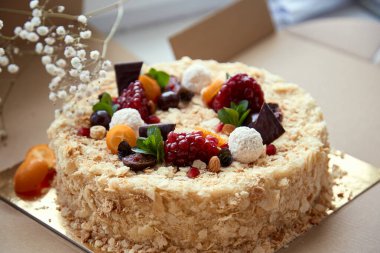 Meyve, nar tohumu, çikolata ve üzümle süslenmiş doğum günü pastası. Üst görünüm