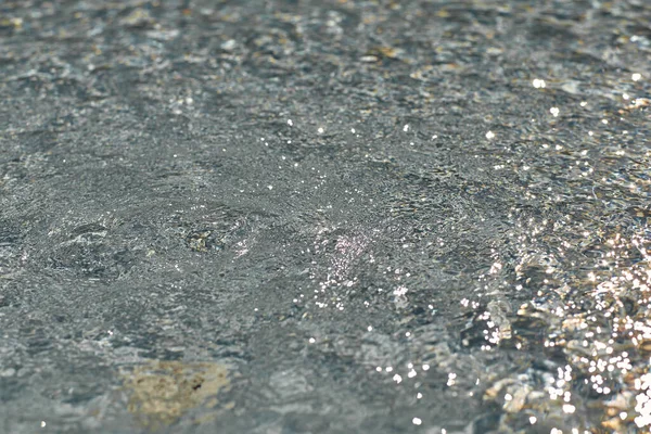 Wateroppervlak in zonnige dag, naadloos patroon, textuur. Natuurlijke achtergrond met bokeh lichten — Stockfoto