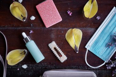 Havalı kadınlar maske, cam şişe, ayna, saç tokası, sarı lale yapraklarıyla çevrili debriyaj patlaması. Üst Manzara. Modern zarif kadınsı konsept