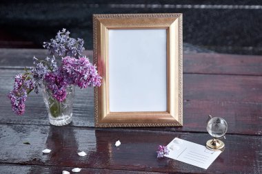 Zarif bir çerçeve, leylak çiçekleri, küre ve hediye kartı. Modern iç mekan, minimalist konsept. Uzayı kopyala Moda şablonu. Eğilim işlemi