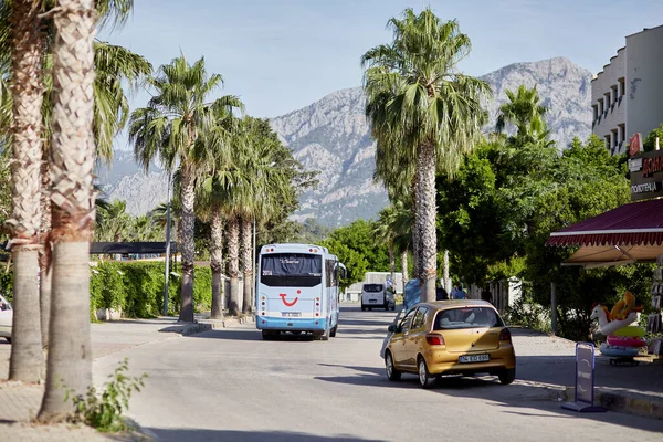 Kemer, Türkiye - 24 Mayıs 2021: Güneşli bir günde TUI seyahat otobüsü, çiçek açan ağaçlar, palmiyeler, yeşil doğa, arabalar, otobüs ve yol tabelaları ile gezinti. Yaşam tarzı editör görüşü. Yüksek kalite fotoğraf