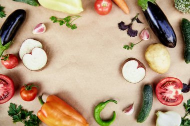 Vegetable frame: beet, basil, eggplant, parsley, bell pepper, hot pepper, potatoes, cucumber, carrots. Italian vegetable recipe. Veganism concept food.Top view, copy space