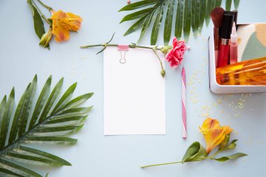 Yaratıcı, taze kozmetik şişesi maketi ve parlak çiçekler. Dilek listesi kartpostal ve kalemle hazırlanır. Kartpostal veya davetiye maketi. Üst görünüm, boşluğu kopyala. Yüksek kalite fotoğraf