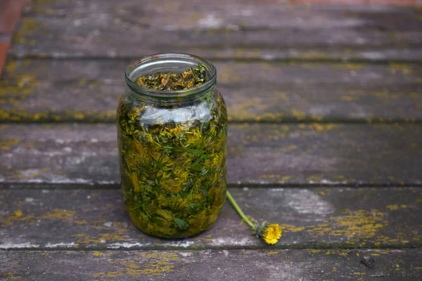 Dandelion tincture is a natural homeopathic remedy at home. Natural cosmetic and medical product. Dandelion infused in alcohol. Rustic background. Top view