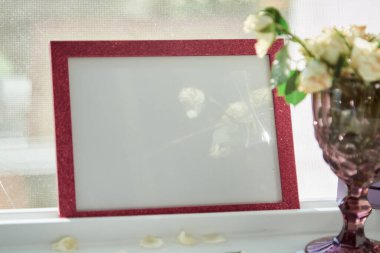 Pembe çerçeve, güneş ışığı ve beyaz güllü şarap kadehiyle uyumlu. Seçici odaklanma. Yüksek kalite fotoğraf